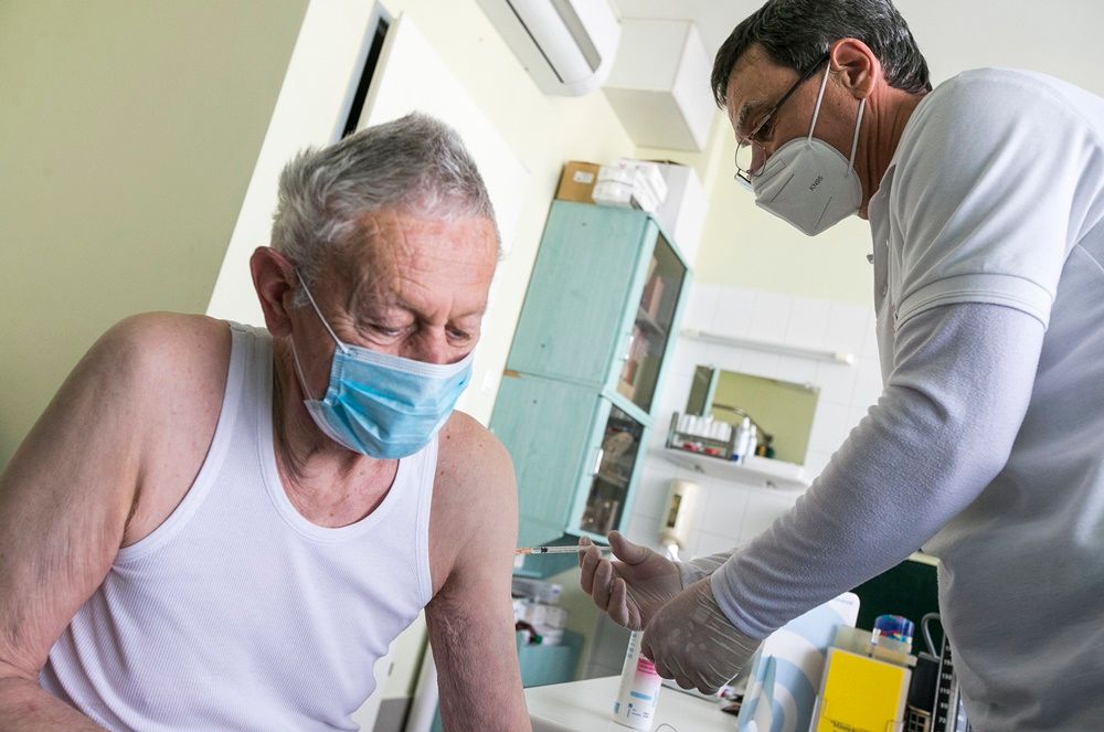 Fotó: Gaszner András háziorvos a Pfizer-BioNTech koronavírus elleni vakcina első adagjával olt be egy idős férfit kecskeméti rendelőjében 2021. március 16-án. MTI/Bús Csaba