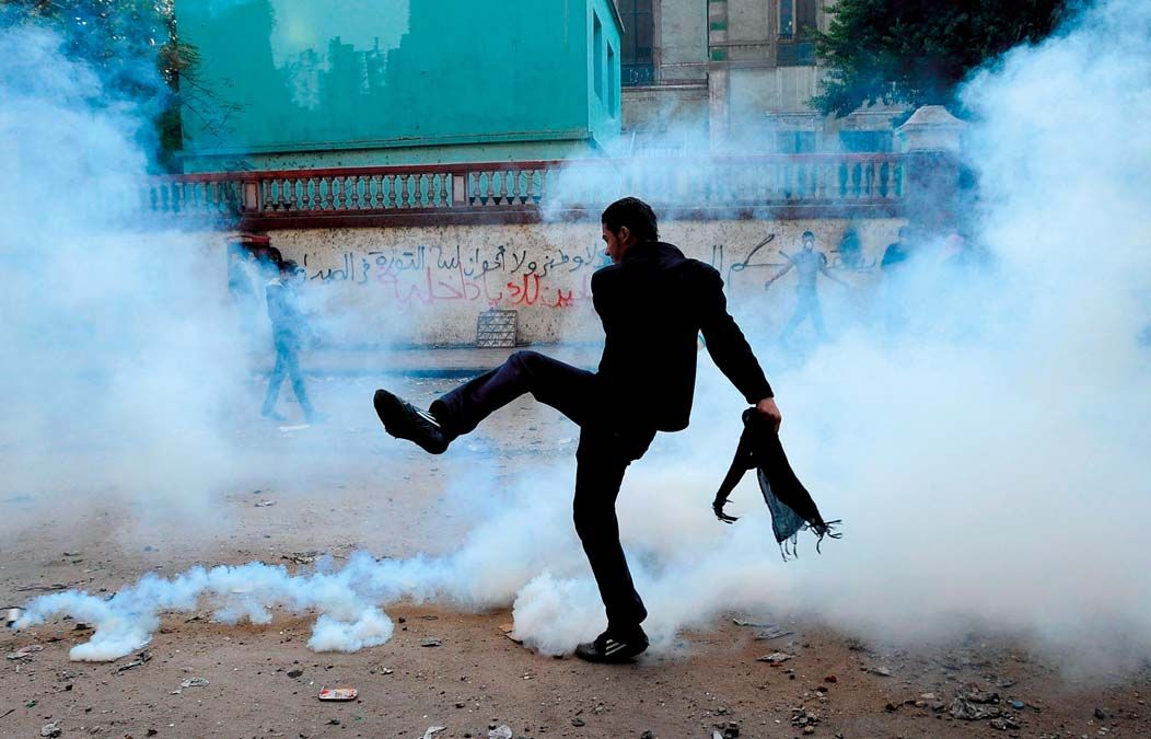 Tüntető rúg bele egy könnygázgránátba Kairóban  2011. november 21-én. <br> Fotó: MTI / EPA / Mohamed Omar