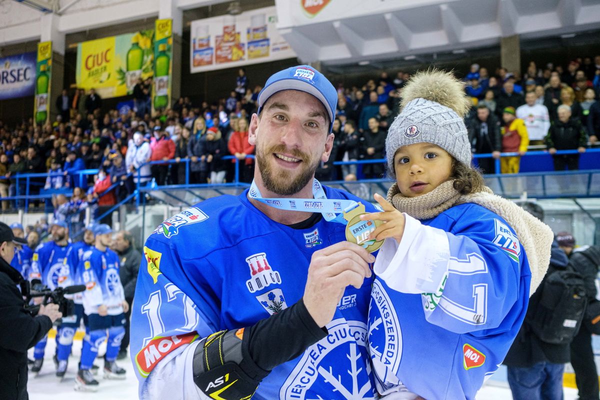 Sofron István, az SC Csíkszereda játékosa bajnoki aranyérmét mutatja, karján kislánya. Fotó: MTI/Veres Nándor