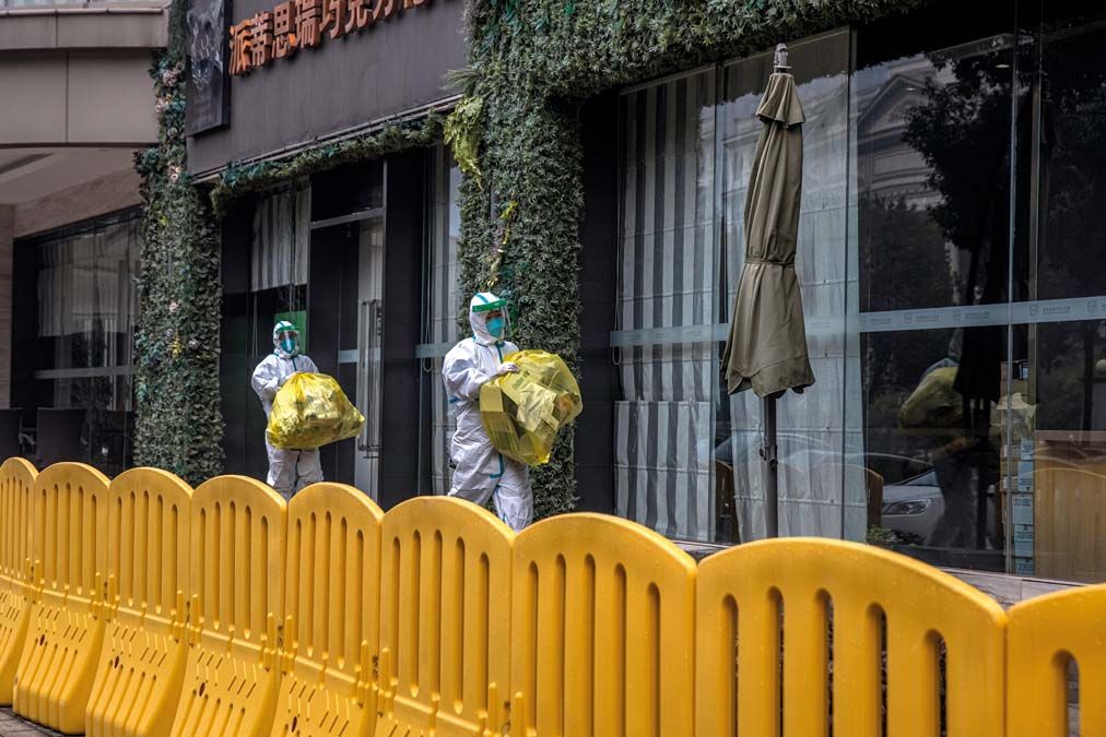 Védőruhába öltözött alkalmazottak a Jade Boutique szálloda épülete előtt Vuhanban az év elején. <br> Fotók: MTI / EPA / Roman Pilipej 