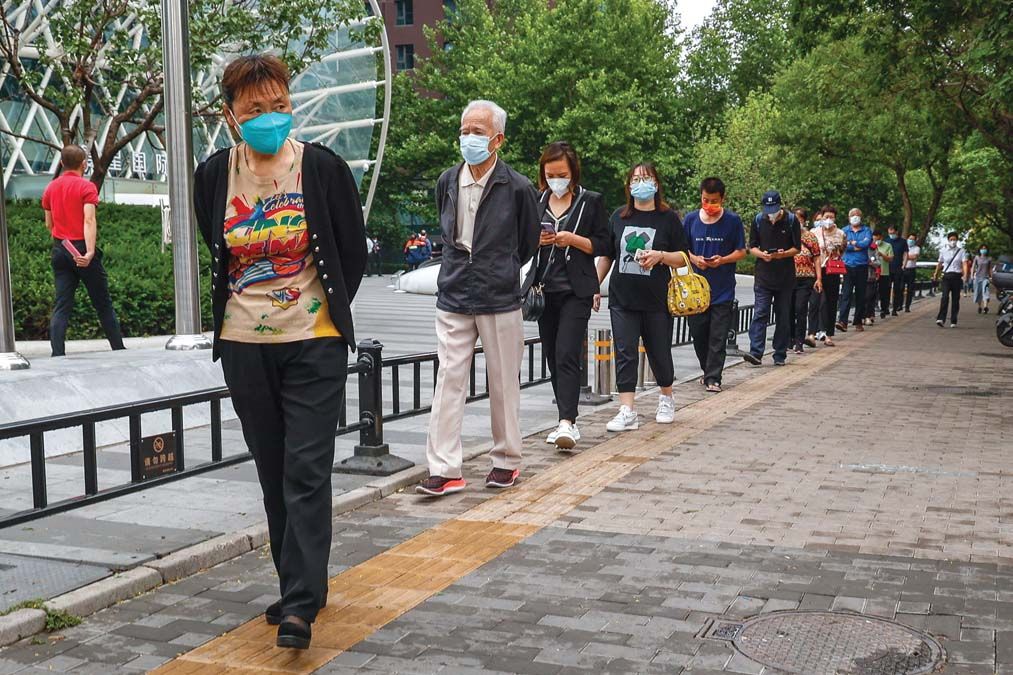 Koronavírus-tesztelésre váró emberek sorakoznak egy pekingi tesztállomás előtt júniusban <br> Fotó: MTI / EPA / Mark R. Cristino