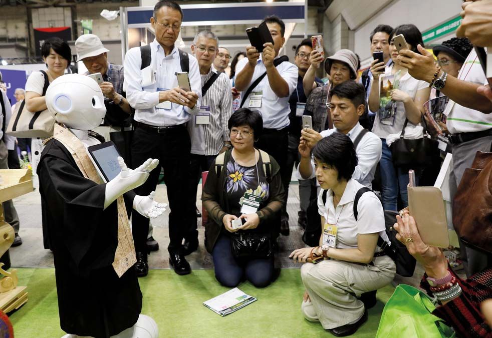 Pepper, a japán Softbank távközlési-informatikai konszern humanoid robotja beszél a tokiói nemzetközi temetkezési kiállításon  2017. augusztus 25-én. Pepper a világ első olyan robotja, amely képes az emberek érzelmi reakcióinak és testbeszédének  olvasására. Az elsajátított információkat feltölti egy felhőalapú tárhelyre, ahonnan a többi robot is megtanulhatja őket. <br> Fotó: MTI / EPA / Majama Kimimasza