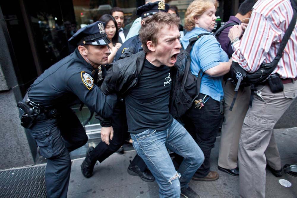 Életkép a Foglaljuk el a Wall Streetet (Occupy Wall Street) mozgalom amerikai tüntetéseiről 2012 szeptemberéből. A rendőrség több tucat tüntetőt előállított, aki a mozgalom megalakulásának első évfordulója alkalmából megpróbálta bekeríteni a tőzsdét és megbénítani  a közlekedést Manhattan üzleti negyedében<br>Fotó: MTI / EPA / Ramin Talaie