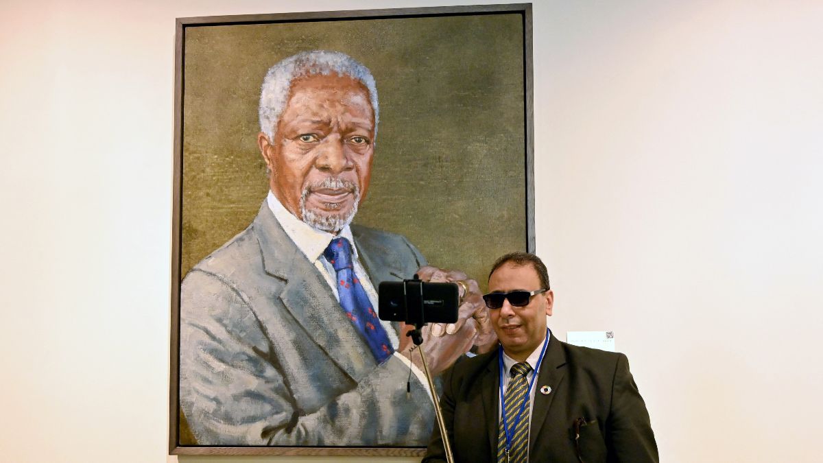 Egy ember selfie-zik Kofi Annan portréja előtt. <br> Fotó: Angela Weiss / AFP