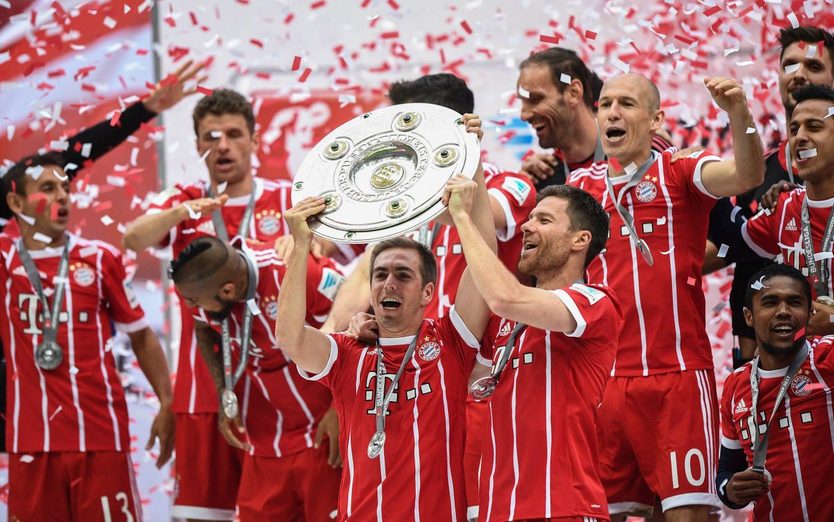 Philipp Lahm (k) és Xabi Alonso (j), a Bayern München labdarúgócsapat visszavonuló játékosai ünnepelnek a bajnoki trófeával a müncheni Allianz Arénában 2017. május 20-án. A bajor csapat akkor is a 31. fordulóban védte meg címét. Fotó: MTI/EPA/Christina Bruna