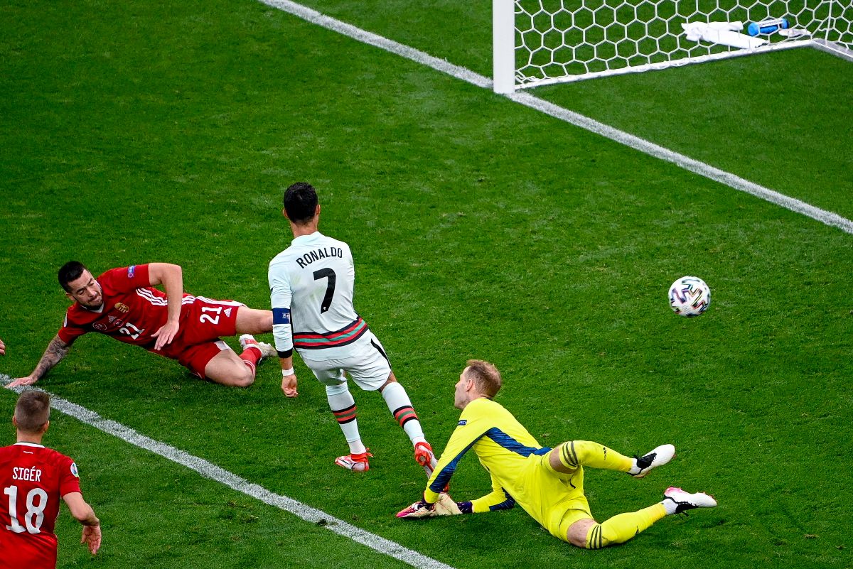 A portugál Cristiano Ronaldo (k) gólt lő Botka Endre (b) és Gulácsi Péter kapus (j) között<br>Fotó: MTI/Szigetváry Zsolt