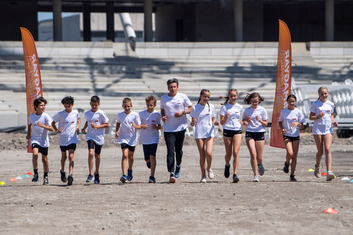 A képen: Sebastian Coe, a Nemzetközi Atlétikai Szövetség (IAAF) elnöke gyerekekkel fut az épülő Nemzeti Atlétikai Központban 2022. június 18-án. Látogatásán Sebastian Coe futotta az első métereket az új, még épülő Nemzeti Atlétikai Központban, ahol alig több mint egy év múlva az atlétikai világbajnokságot rendezik. MTI/Balogh Zoltán
