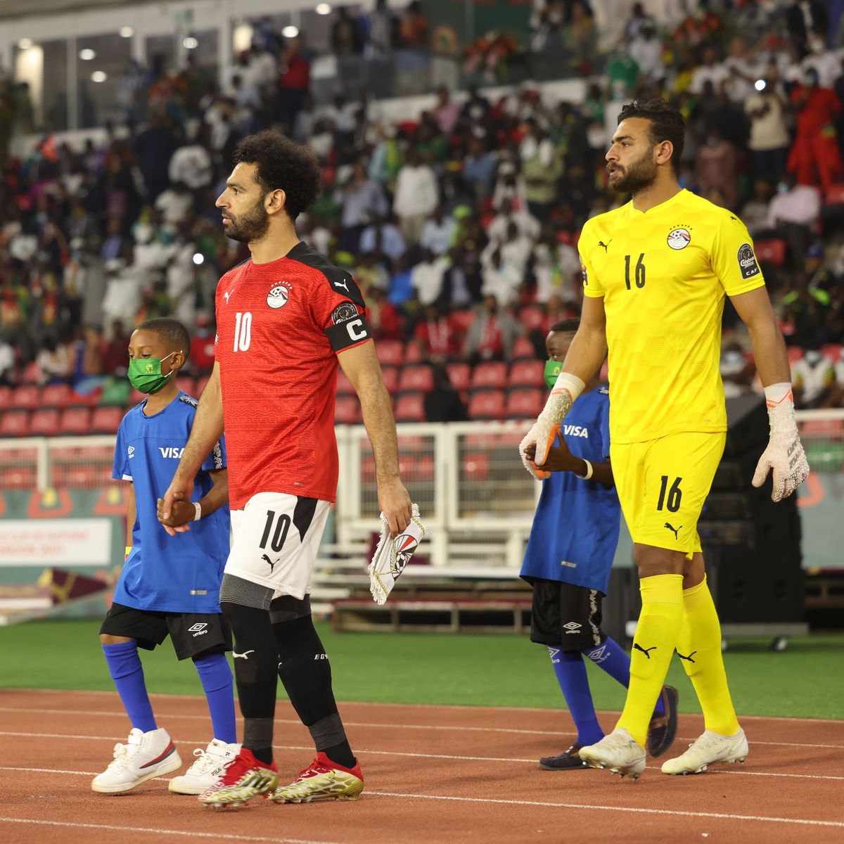 Az egyiptomi Mohamed Szalah (balra) és Gabaszki (jobbra) megy ki a pályára az Afrika-kupa döntőjére Szenegál ellen. A fináléban ők ketten játszottak a legjobban az egyiptomi labdarúgó-válogatotban. TotalEnergies Africa Cup of Nations hivatalos Facebook-oldala.
