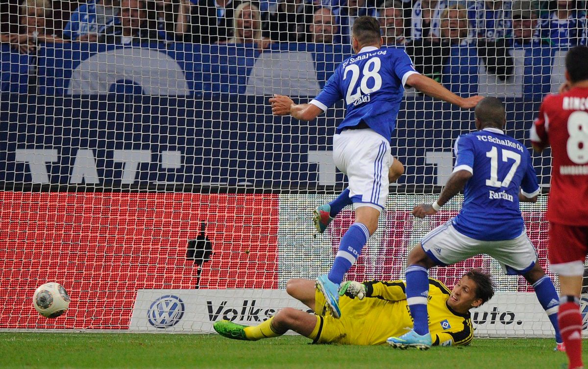 Szalai Ádám, a Schalke 04 magyar játékosa (28) gólt szerez Rene Adler, a Hamburger SV kapusa (lent) ellen a német első osztályú labdarúgó-bajnokság 2013. augusztus 11-i mérkőzésén Gelsenkirchenben. Fotó: MTI/EPA/Marius Becker