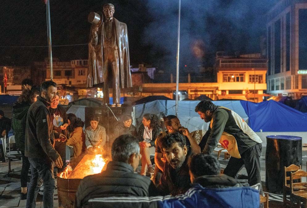 Tűznél melegedő emberek a földrengés sújtotta Hatay tartományban <br> Fotó: AFP / Bulent Kilic