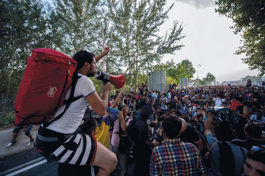 Több száz migráns demonstrál Röszkénél 2015. szeptember 16-án. Néhány hangadó vezetésével  többen áttörték a kaput a határ szerbiai részén.<br>Fotó: MTI / Sóki Tamás