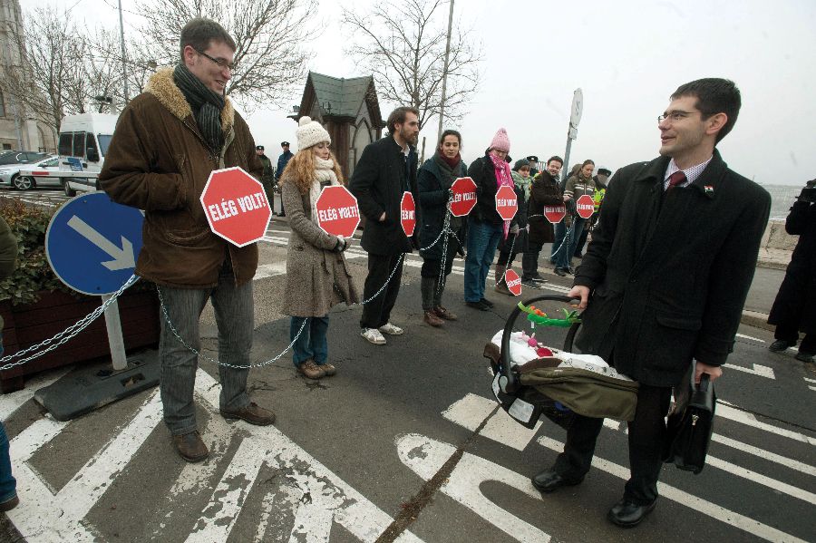 A Lehet Más a Politika képviselői és aktivistái az autóbejárat egyik oszlopához láncolták magukat a választójogi törvényről szóló szavazás napján, 2011. december 23-án. <br> Fotó: MTI / Koszticsák Szilárd