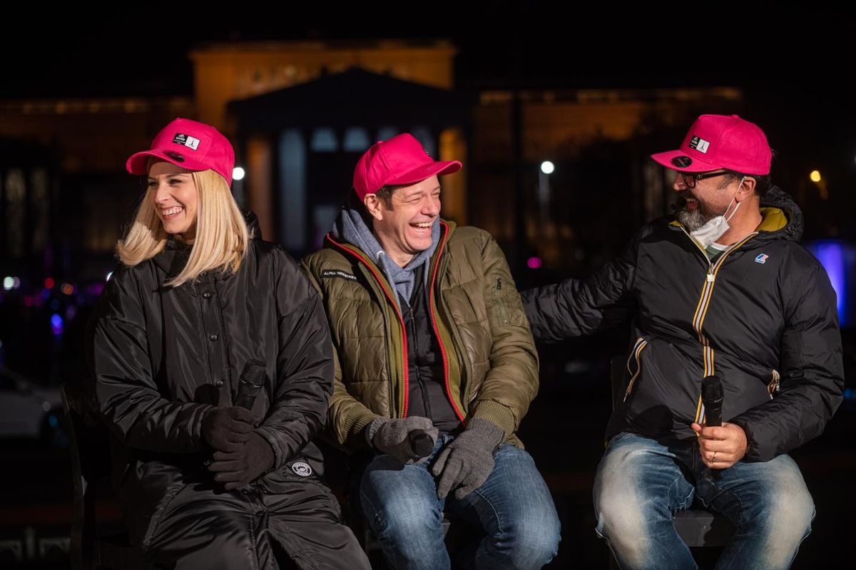 A Giro Hungary 2022 nagykövetei, Tápai Szabina (balra), Tilla (középen) és Gianni (jobbra) a rózsaszín fénnyel megvilágított budapesti Hősök terén a Giro d'Italia országúti kerékpáros-körverseny magyarországi rajtja előtt 100 nappal 2022. január 26-án. Giro Hungary 2022 Facebook-oldala