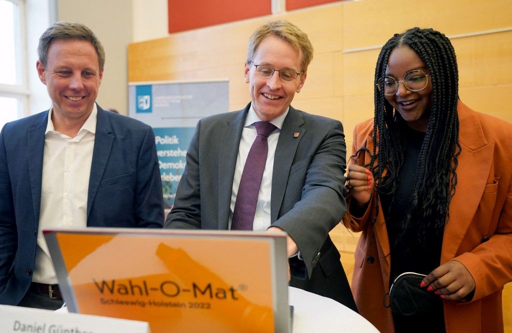Vidám a kampány Schleswig-Holsteinban: Thomas Loose-Müller (b), Daniel Günther és Aminata Touré közösen nézik meg a Magyarországon Vokskabin néven ismert Wahl-O-Mat helyi választásra készített változatát a kieli parlamentben. Fotó: MARCUS BRANDT / DPA / dpa Picture-Alliance via AFP