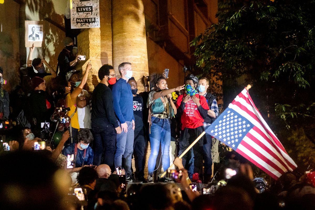 „Ha gázt kaptok, én is gázt kapok!” – Ted Wheeler (középen, kékben) a tüntetőkkel. Fotó: MTI/AP/Noah Berger