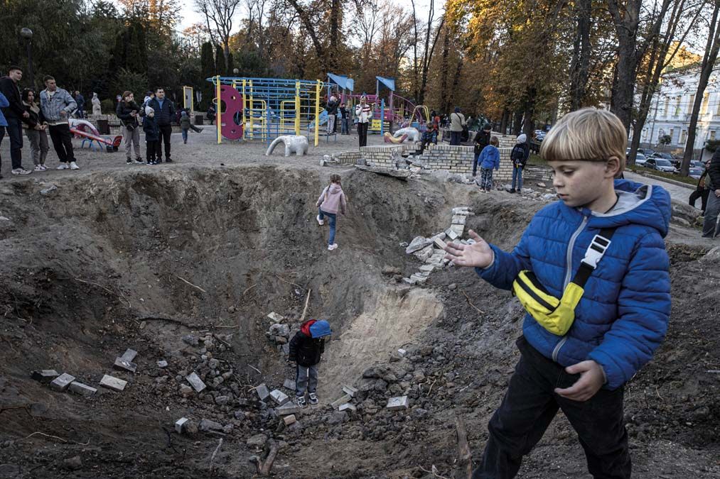 Robbanás utáni kráterben játszó gyerekek Kijevben október 16-án <br> Fotó: Metin Aktas / ANADOLU AGENCY