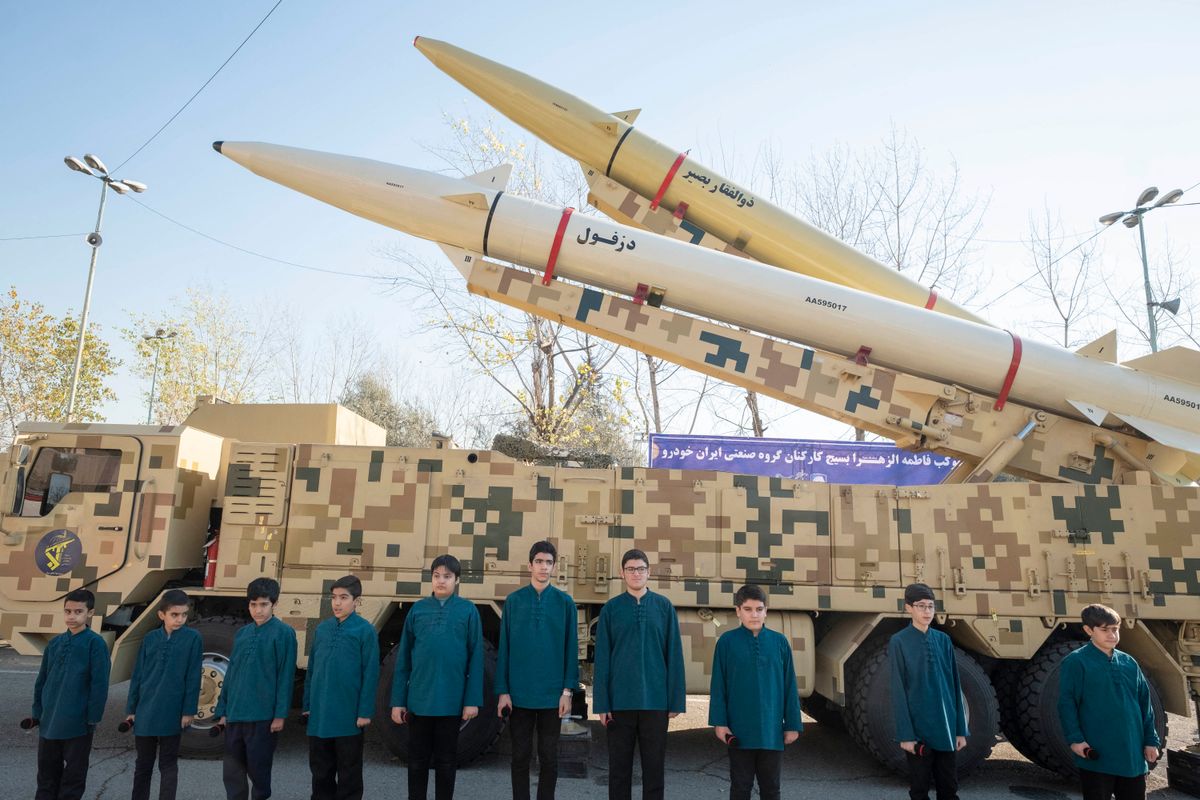 Iráni iskolások egy közszemlére kitett Zolfaghar közép hatótávolságú rakéta előtt pózolnak Teheránban 2022. január 7-én   (forrás: Morteza Nikoubazl / NurPhoto via AFP)