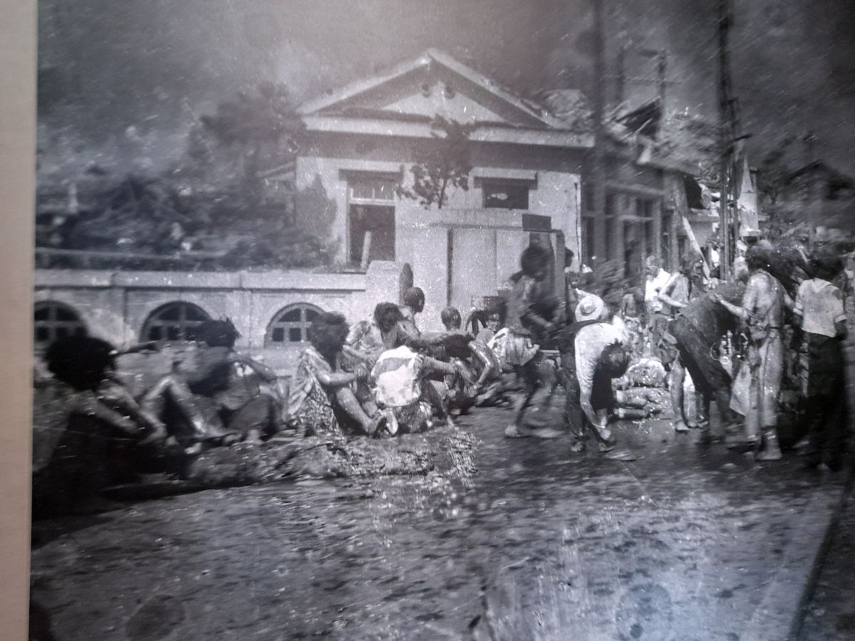 A hirosimai atomtámadás után készült első fotó: negyedórával a detonáció után sebesültek gyülekeznek az utcán  –  a kép a hirosimai emlékmúzeum tárlatában látható