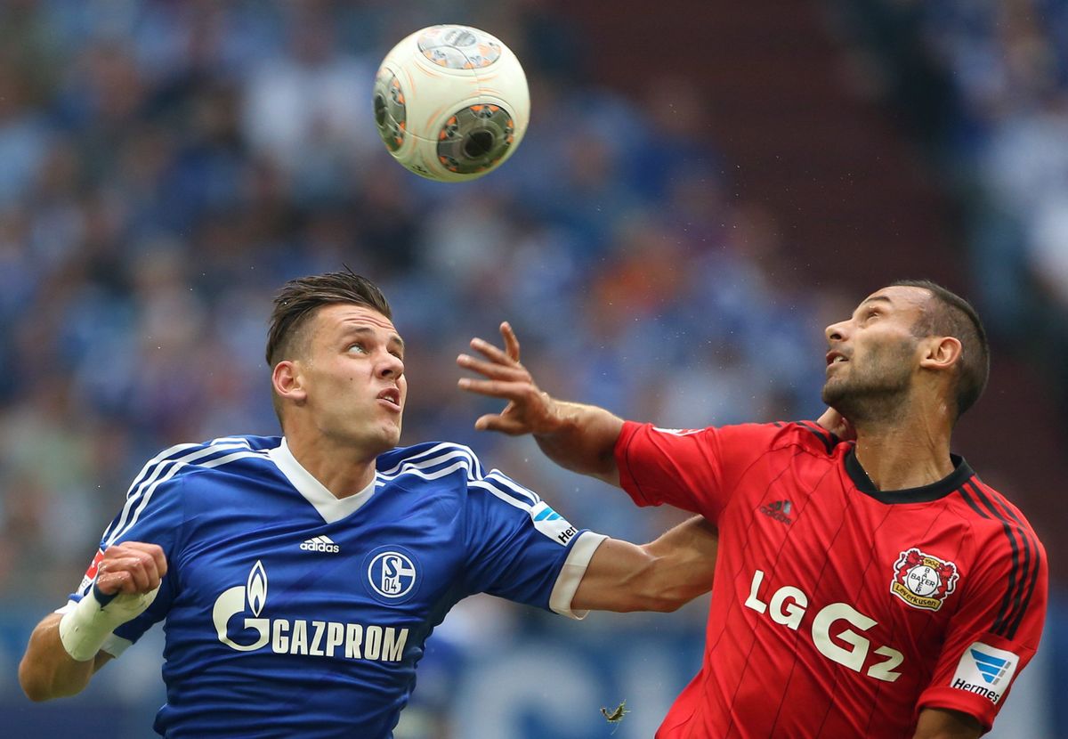 Szalai Ádám, a Schalke 04 magyar csatára (b) és Ömer Toprak, a Bayer Leverkusen játékosa a 2013. augusztus 31-i mérkőzésen a gelsenkircheni Veltins Arénában. Fotó: MTI/EPA/Friso Gentsch