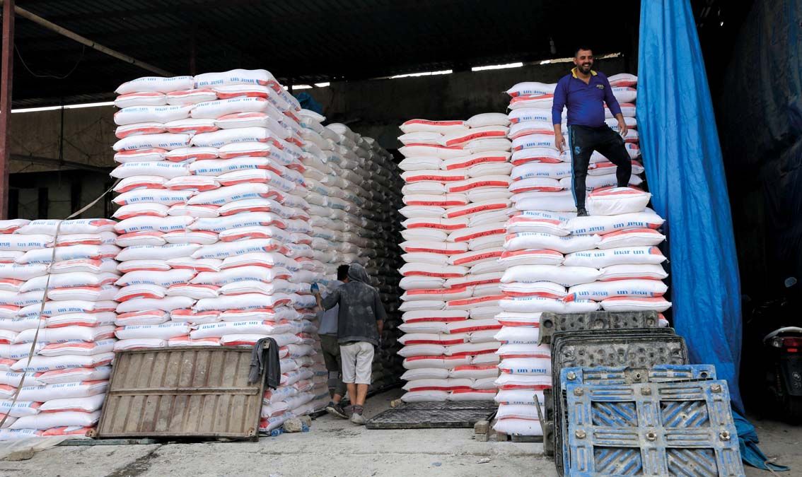 Importált búzát tartalmazó zsákokon áll egy munkás egy bagdadi nagykereskedelmi piacon idén márciusban.  Musztafa al-Kádimi miniszterelnök bejelentette, hogy rendkívüli ülést tart a kormány, miután jelentős mértékben emelkedett az élelmiszerek ára az ukrajnai háború következtében <br> Fotó: MTI / EPA / Ahmed Dzsalil,