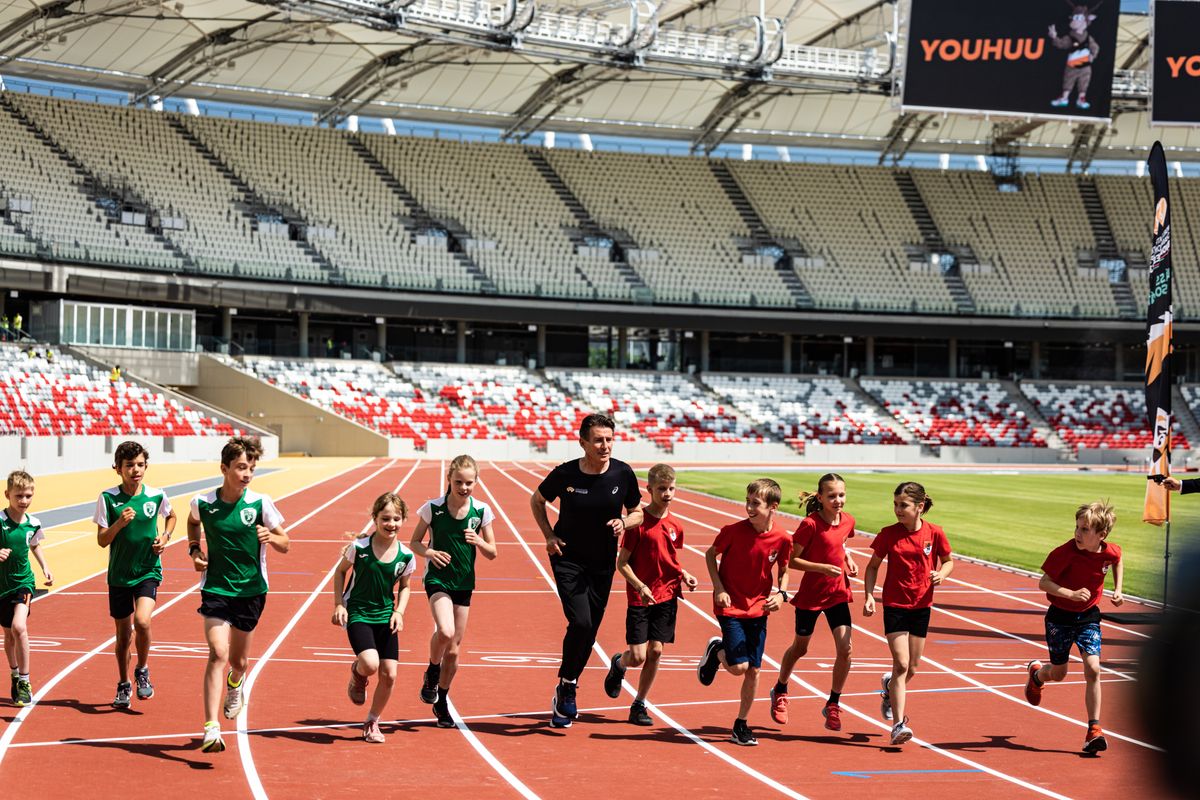 Sebastian Coe, a Nemzetközi Atlétikai Szövetség elnöke ifjú magyar sportolókkal lefutja az első kört a Nemzeti Atlétikai Stadionban (kép: Földházi Árpád, Mandiner)