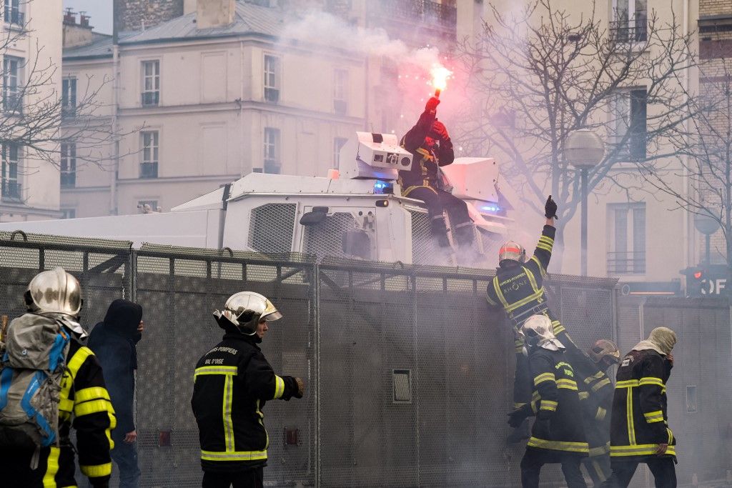 A firefighter managed to climb on a water cannon before being hit by a LBD shot on Tuesday 28th January 2020, at the call of the Professional Firefighters' Unions several thousands of firefighters demonstrated in Paris between the Place de la République and the Place de la Nation to demand the revaluation of the fire bonus and their retirement. Clashes with the police broke out along the route of the procession and at the end of the demonstration where a few hundred people tried to break a bridge bar, the riot police used water cannons and tear gas grenades and the new GM2L grenades to repel them. (Photo by Samuel Boivin/NurPhoto) (Photo by Samuel Boivin / NurPhoto / NurPhoto via AFP)