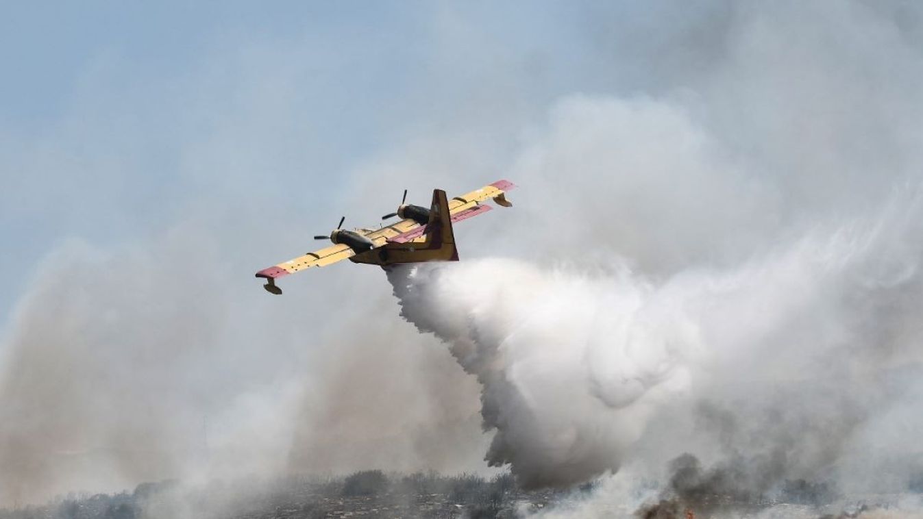 A canadair drop water onto a wildfire near the city of Volos, central Greece, on July 27, 2023. Greek fire crews on July 27 scrambled to put out wildfires raging for two weeks around the country that left five dead before strong winds forecast for the day rekindle blazes.