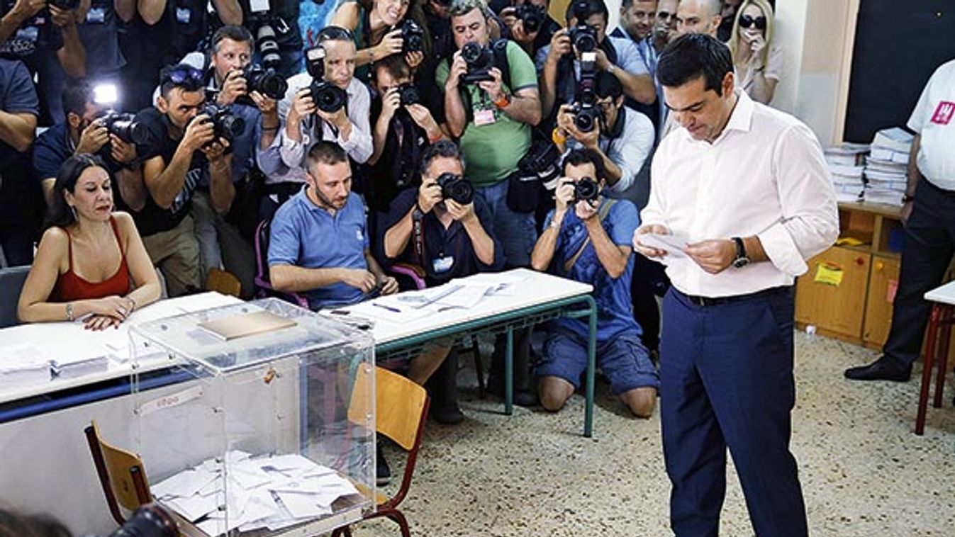 Greek Prime Minister Alexis Tsipras looks at his ballot before voting in national referendum at a polling station in Athens