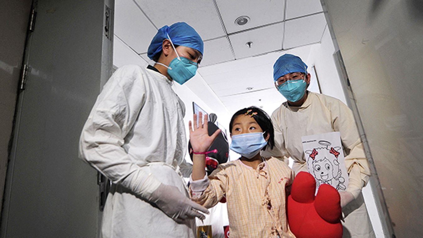 A girl waves as she is being transferred to a public ward from the ICU at Ditan hospital in Beijing