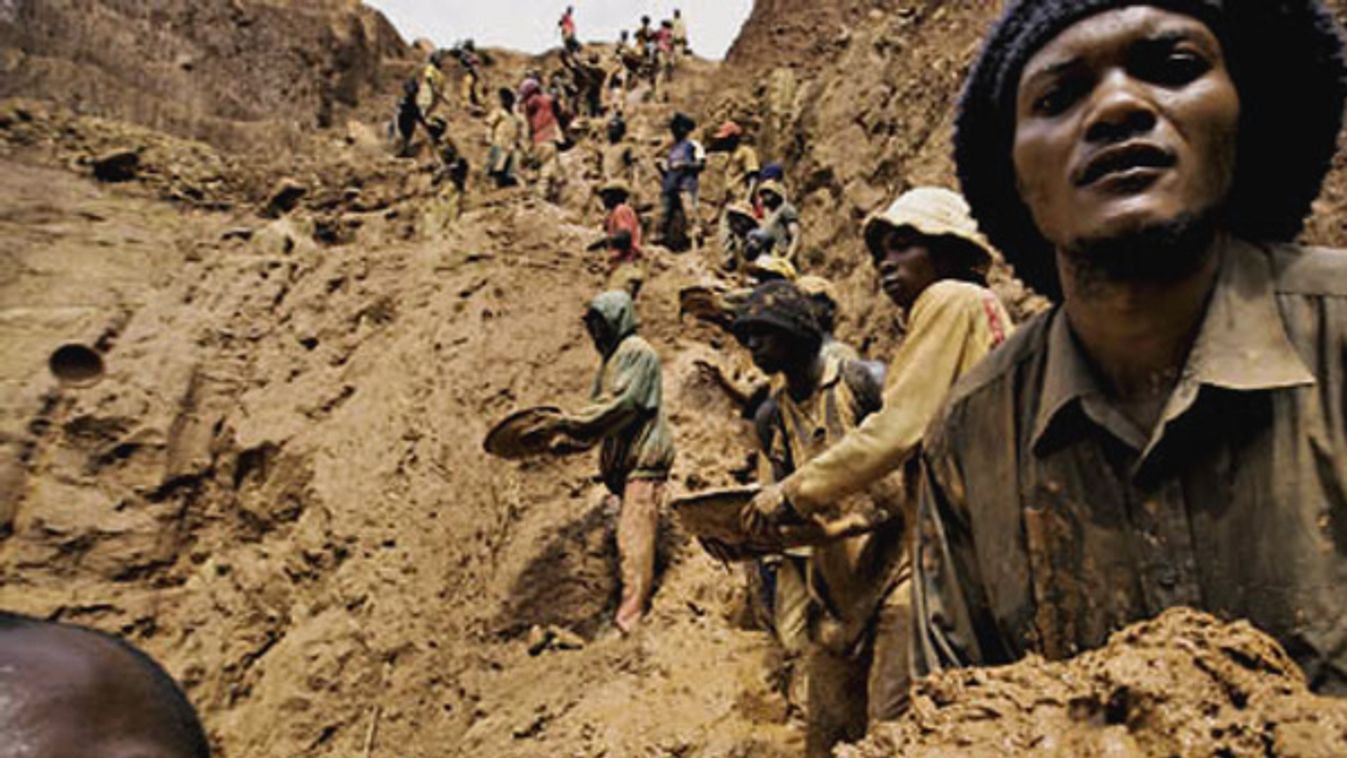 Gold miners form a human chain while digging an open pit in northeastern Congo