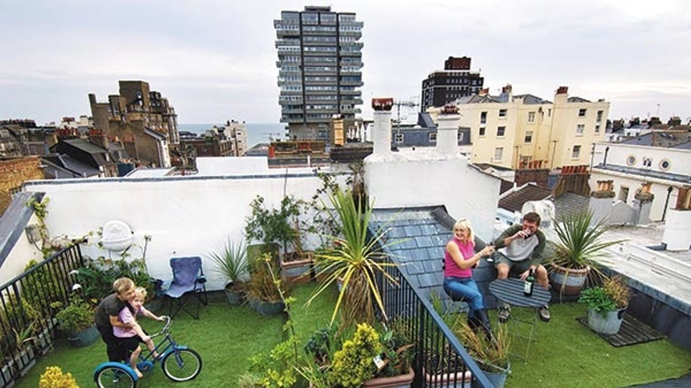 An urban family in the rooftop garden of their home in the city of Brighton and Hove with the sea in