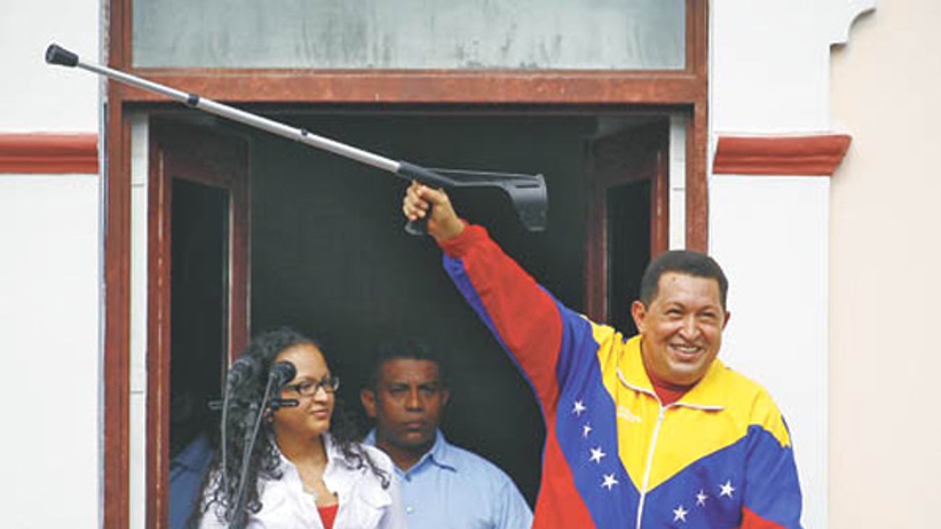 Venezuelan President Chavez holds up a crutch as he greets supporters from 'The People's balcony' at Miraflores Palace at the end of his weekly 'Alo Presidente' broadcast in Caracas