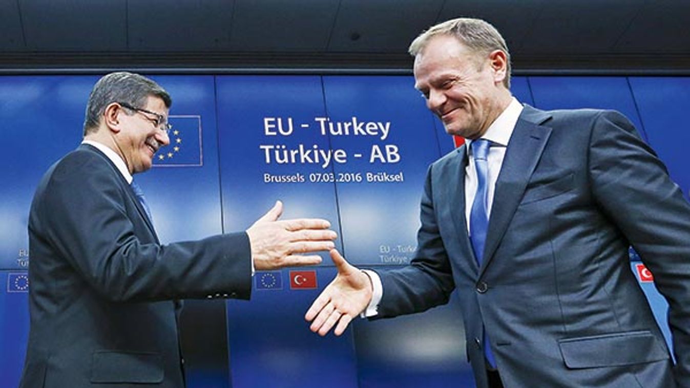 Turkish Prime Minister Ahmet Davutoglu shakes hands with European Council President Donald Tusk after a news conference at the end of a EU-Turkey summit in Brussels 