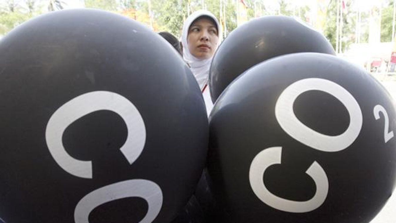 Activist carrying black ballons representing CO2 emission demonstrates in Nusa Dua