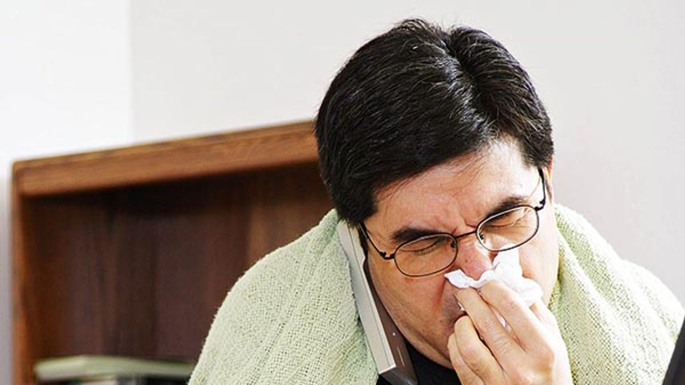 man working from home while being sick