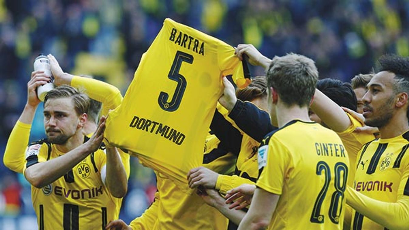 Borussia Dortmund players display a Marc Bartra shirt as they celebrate after the match