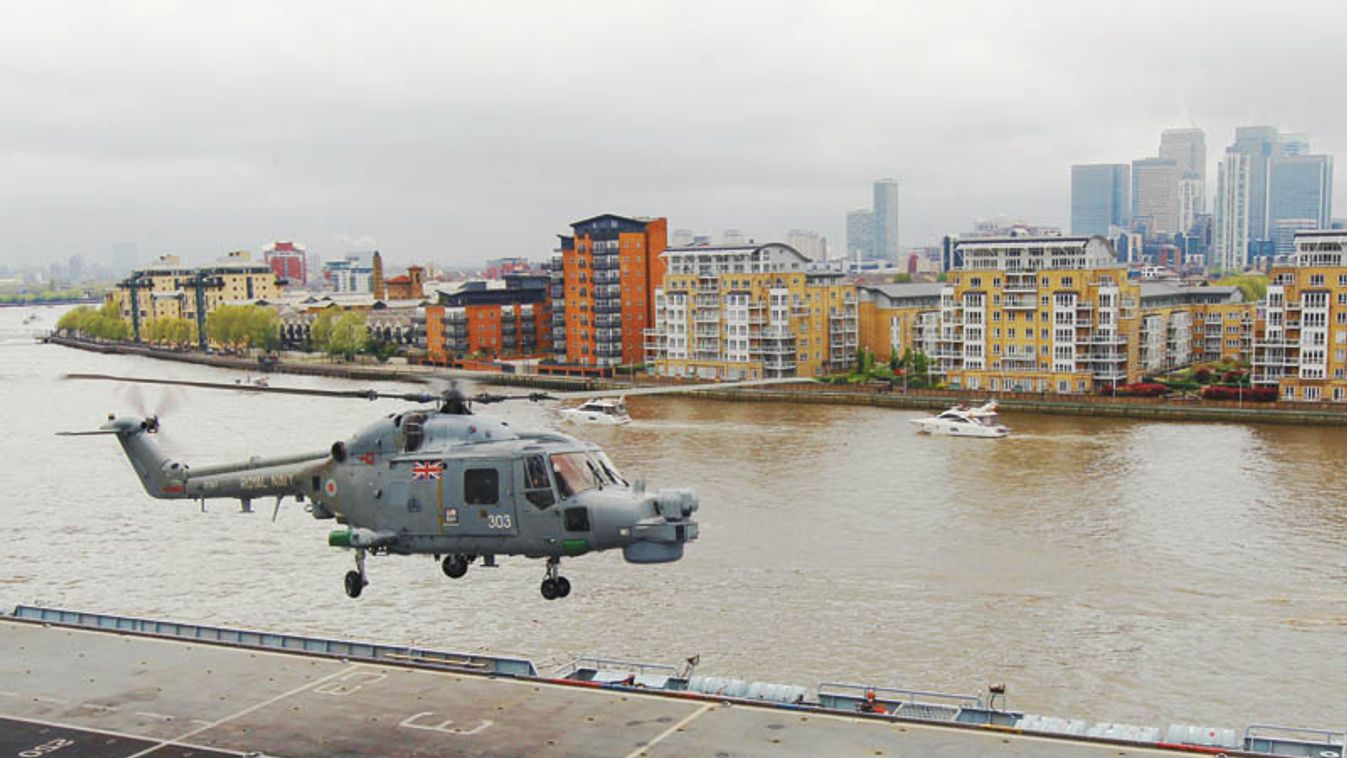 A Lynx helicopter takes off from on board HMS Ocean as the ship sails into London