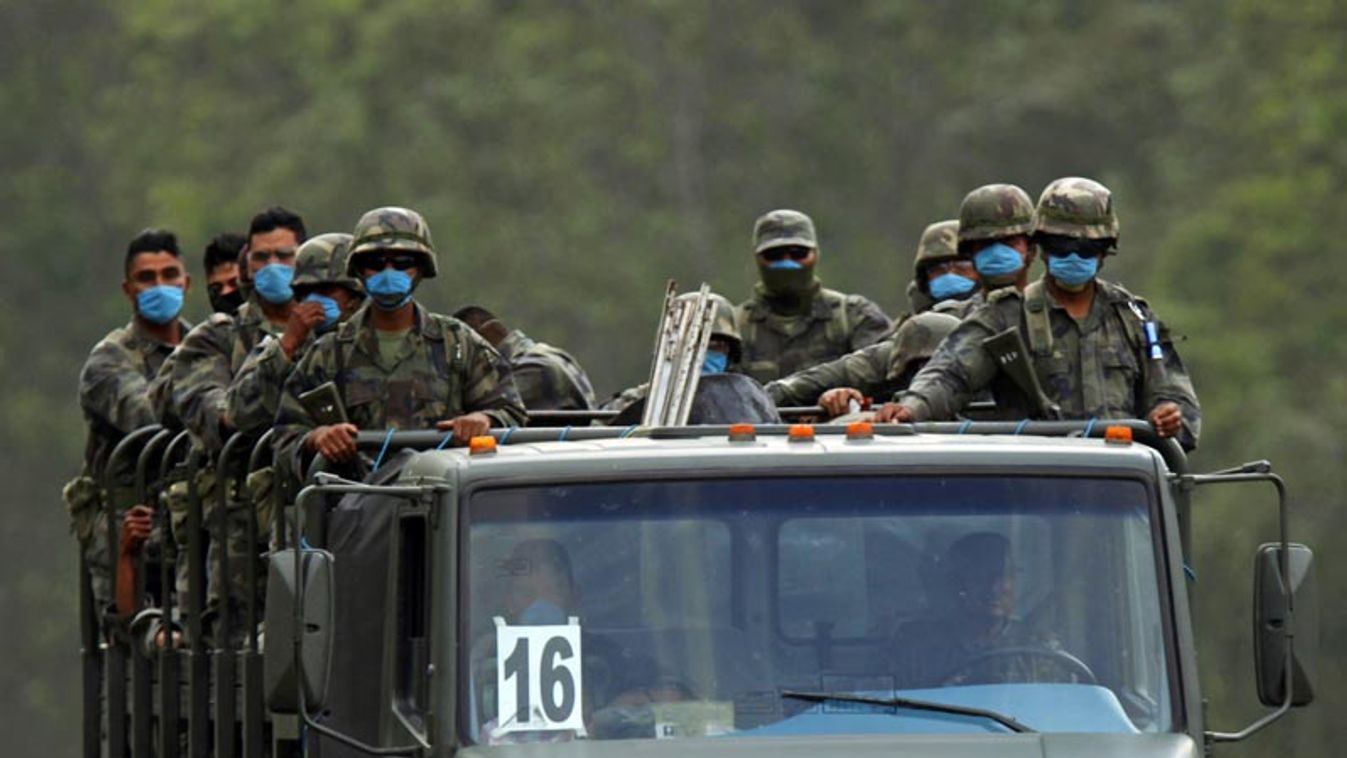 Soldiers wear surgical face masks as they stand on an Army vehicle in Mexico City