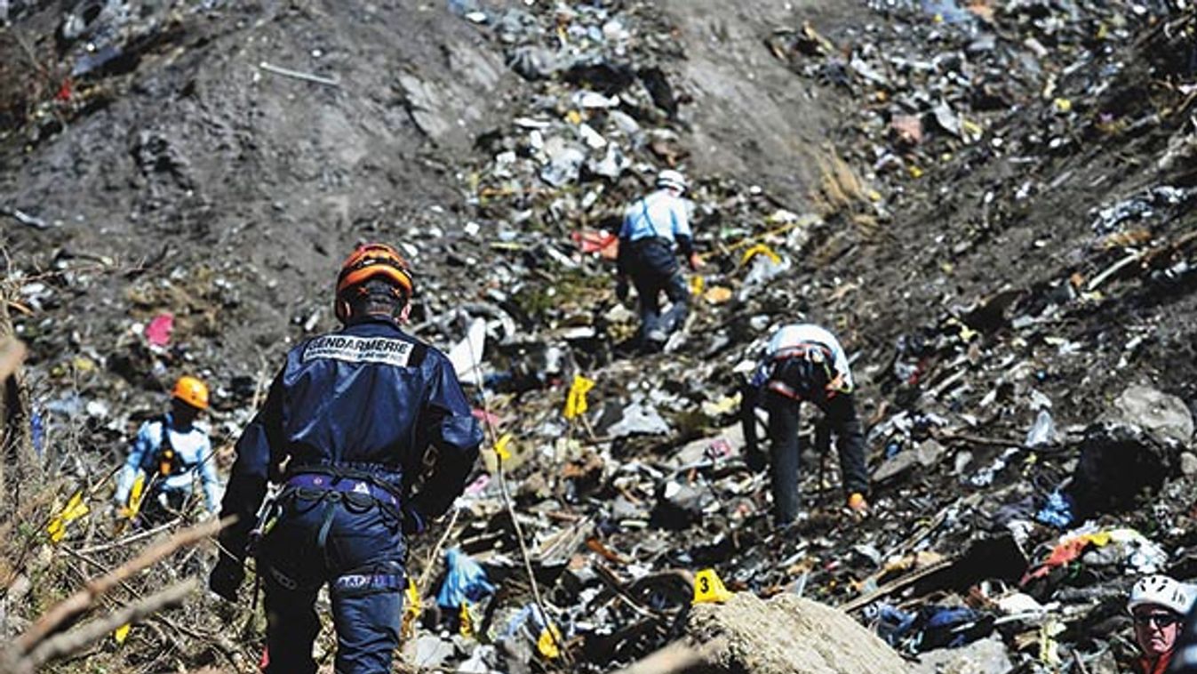 French gendarmes and investigators, seen in this picture released by the French Interior Ministry, make their way through debris from wreckage on the mountainside at the crash site of an Airbus A320, near Seyne-les-Alpes