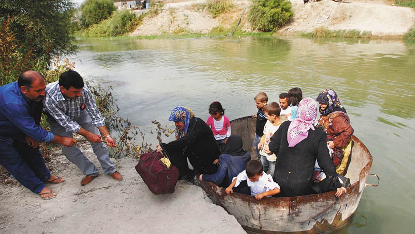 A Syrian family arrives in Turkey after crossing the Orontes river in a water tank, on the Turkish-Syrian border near the village of Hacipasa in Hatay province
