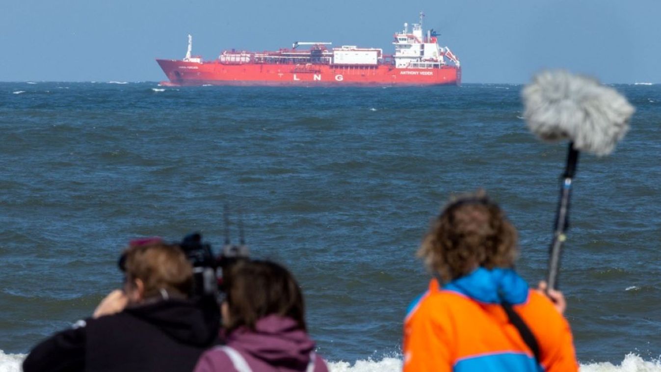 A camera crew films before the meeting of representatives of the German government with associations, mayors and business representatives from Mecklenburg-Western Pomerania on the plans for a liquefied natural gas terminal at the Rügen site on the pier. In the background, an LNG tanker can be seen on the Baltic Sea.