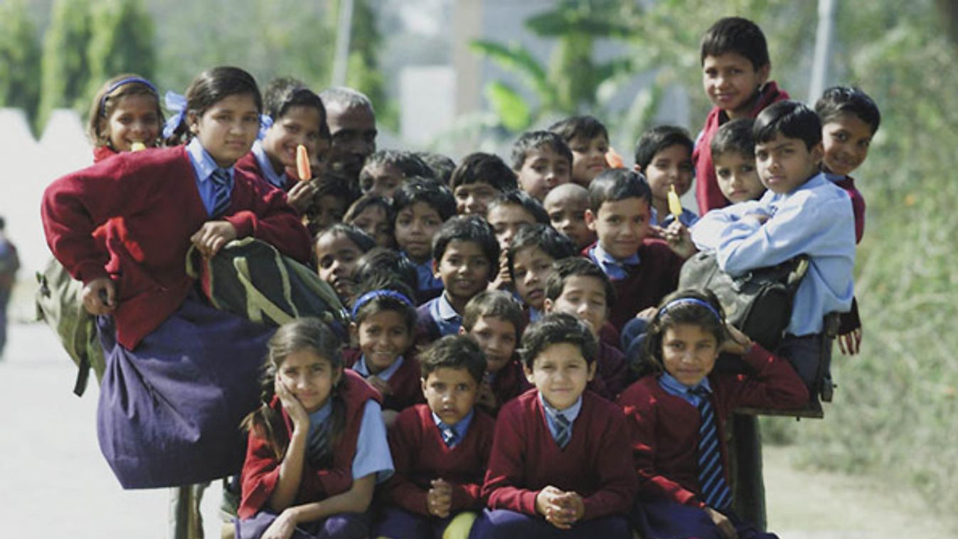 Indian children ride in a cart on the way home from school in the outskirts of New Delhi