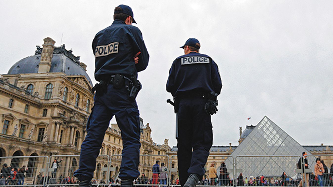 French police patrol next to the Pyramid in the Louvre museum in Paris