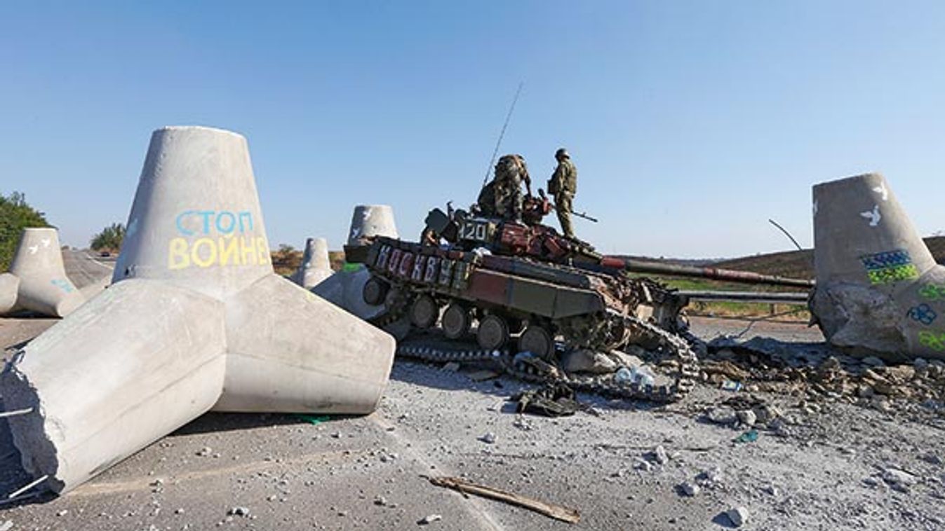 Ukrainian soldiers inspect damaged tank on the outskirts of the southern coastal town of Mariupol