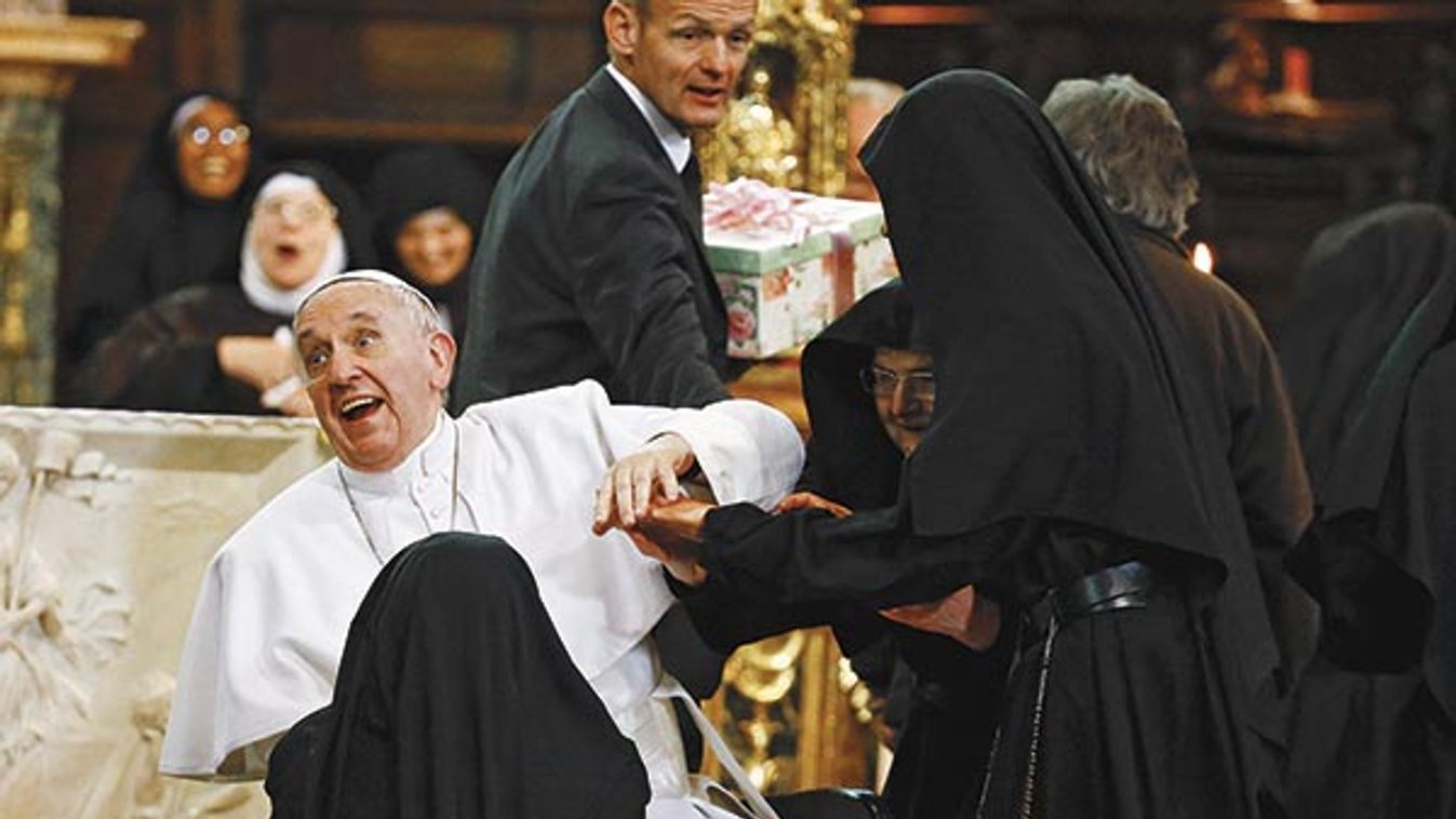 Pope Francis reacts as is greeted by cloistered nuns at the Duomo during his pastoral visit in Naples 