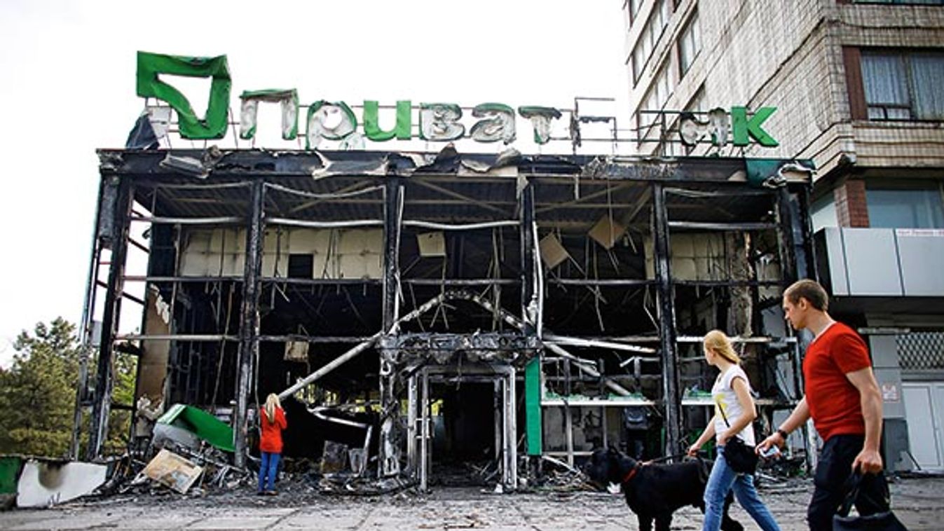 People walk past a gutted branch of Privat Bank near the town hall in Mariupol eastern Ukraine