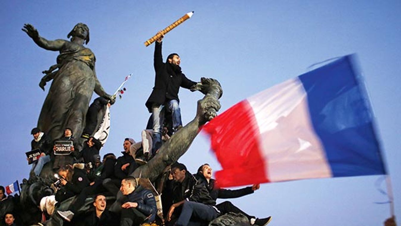 A man holds a giant pencil as he takes part in a Hundreds of thousands of French citizens solidarity march (Marche Republicaine) in the streets of Paris