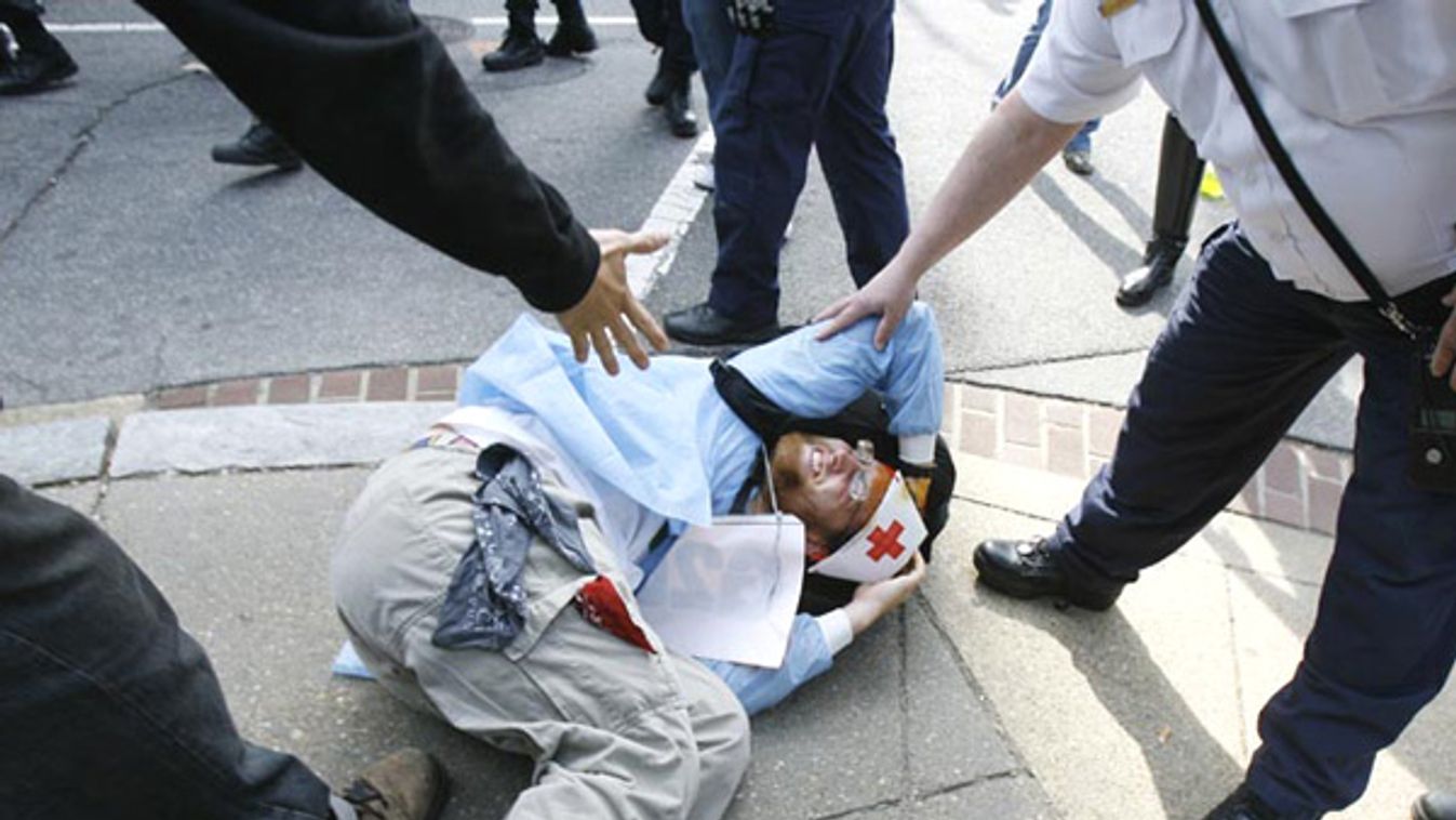 A demonstrator lies injured during a protest march outside the IMF and World Bank buildings in Washington