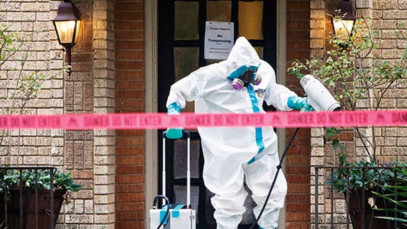 A member of the CG Environmental HazMat team disinfects the entrance to the residence of a health worker at the Texas Health Presbyterian Hospital who has contracted Ebola in Dallas