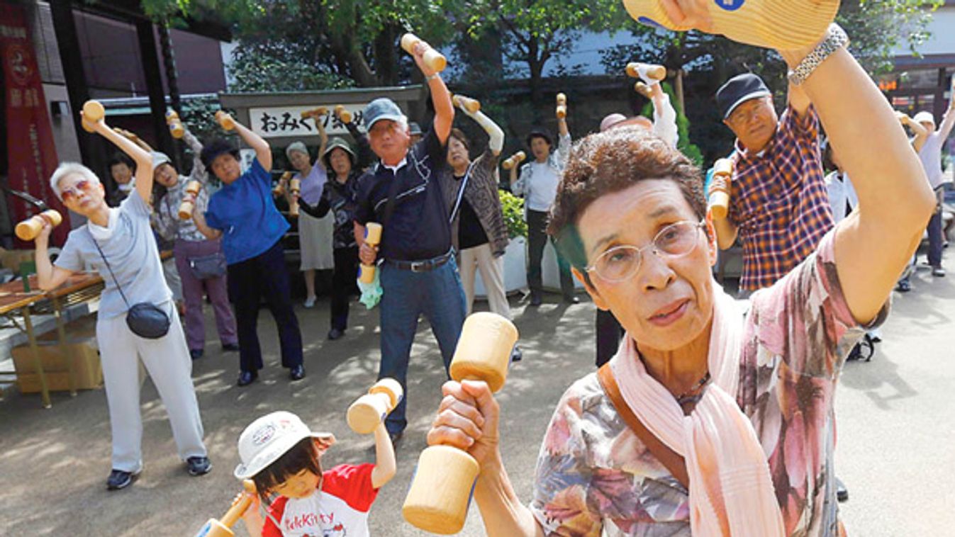 A woman and a girl exercise during a health promotion event to mark Japan's "Respect for the Aged Day" at a temple in Tokyo